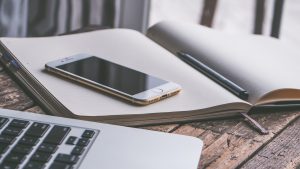 Ordenador portátil y teléfono móvil sobre una mesa, representando la gestión de la presencia digital y el SEO local de un negocio en la era de la IA.